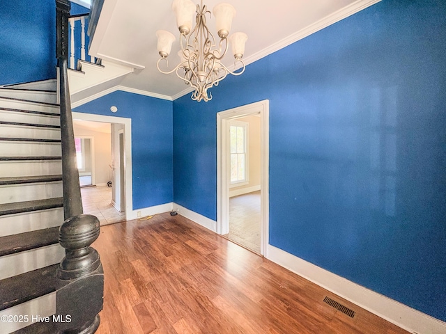 unfurnished room featuring an inviting chandelier, baseboards, crown molding, and stairs