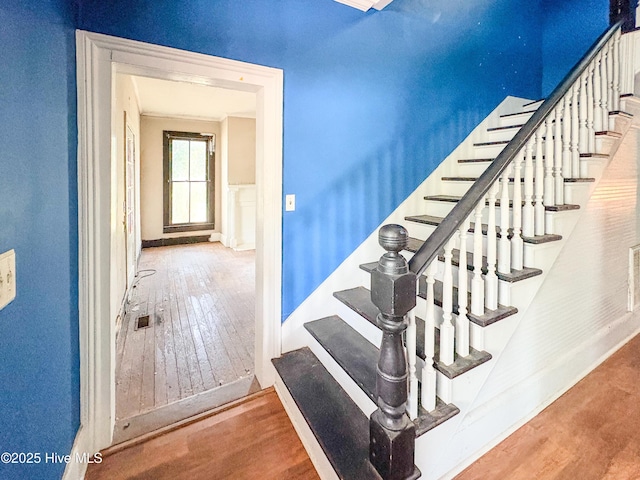 stairway featuring baseboards and hardwood / wood-style flooring