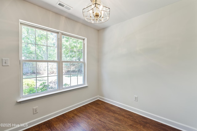 empty room with a notable chandelier, baseboards, visible vents, and a wealth of natural light