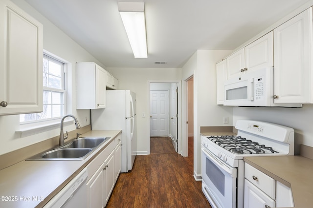 kitchen featuring visible vents, white appliances, dark wood-style floors, white cabinets, and a sink