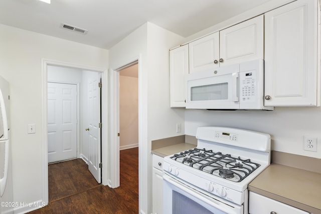 kitchen featuring white appliances, light countertops, white cabinetry, visible vents, and dark wood-style floors
