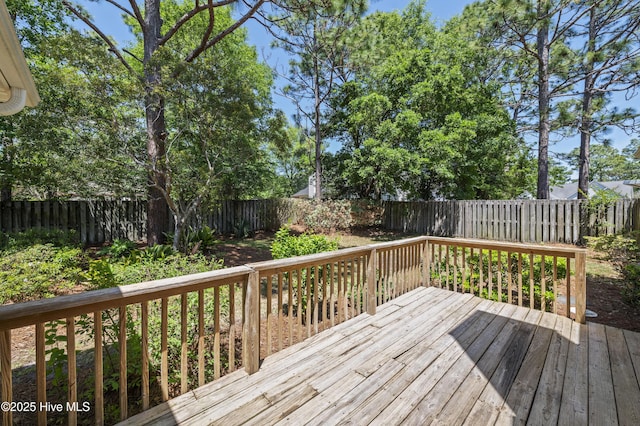 wooden terrace with a fenced backyard