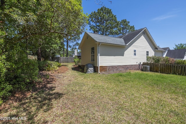 view of property exterior with a yard, cooling unit, a shingled roof, and fence private yard