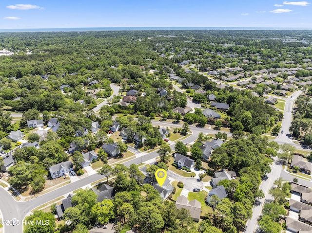 bird's eye view featuring a wooded view and a residential view