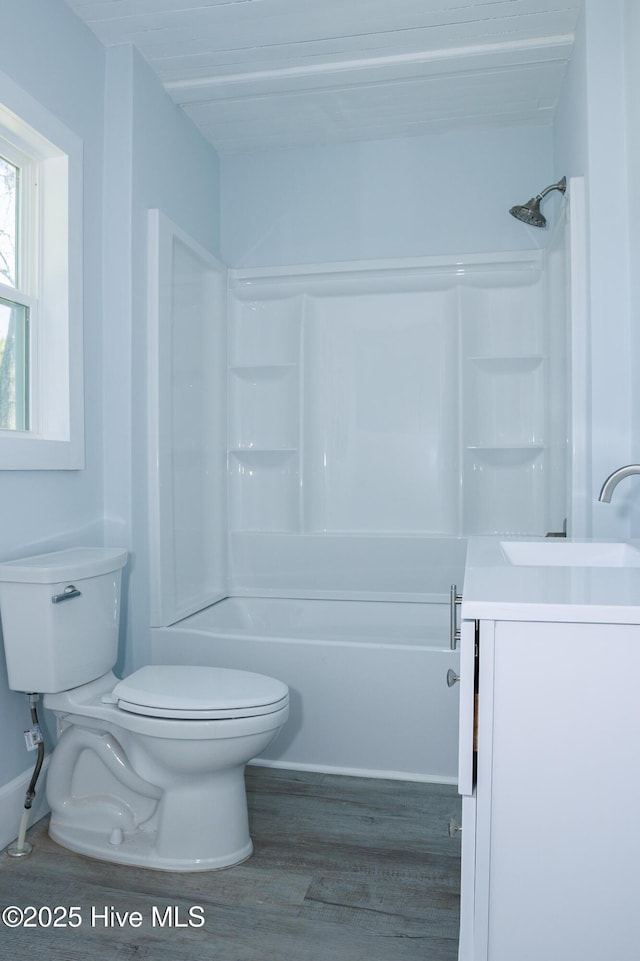 full bath featuring a sink, shower / bathing tub combination, wood finished floors, and toilet