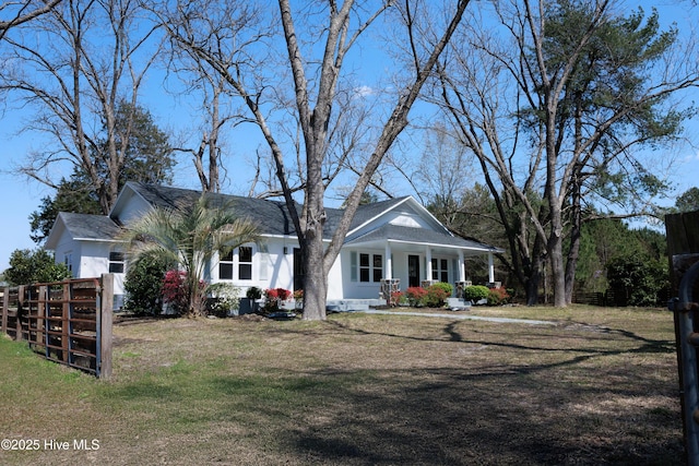 view of front of home with fence, stucco siding, a porch, and a front lawn