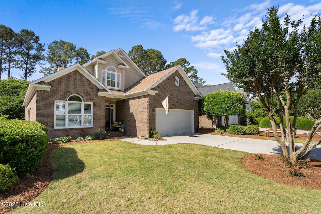 view of front facade with a garage, a chimney, a front yard, brick siding, and driveway