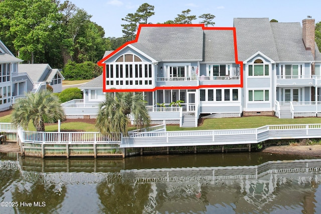 1710 Deerfield Ct SW Unit 4A, Ocean Isle Beach, NC 28469 - rear view of house featuring a balcony, a water view, a chimney, and a shingled roof