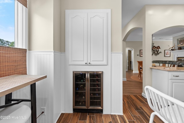 1710 Deerfield Ct SW Unit 4A, Ocean Isle Beach, NC 28469 - bar area with beverage cooler, a wainscoted wall, dark wood finished floors, and arched walkways