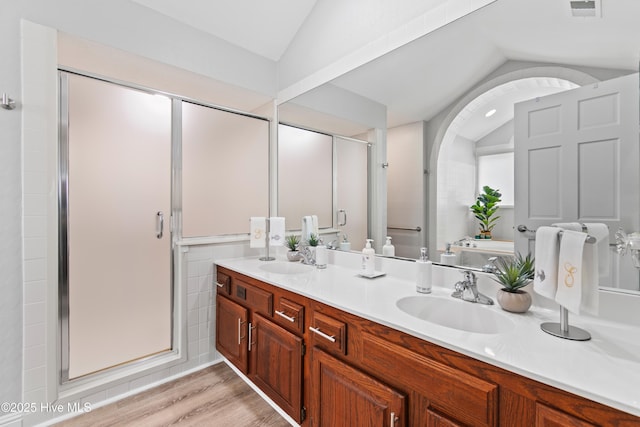 1710 Deerfield Ct SW Unit 4A, Ocean Isle Beach, NC 28469 - full bathroom with lofted ceiling, a shower stall, double vanity, wood finished floors, and a tub to relax in