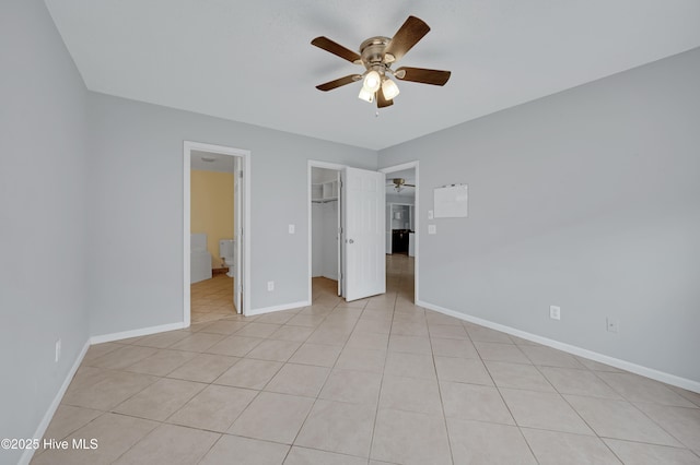 2910 Mulberry Ln Unit B, Greenville, NC 27858 - unfurnished bedroom featuring a walk in closet, light tile patterned floors, a closet, ceiling fan, and ensuite bath