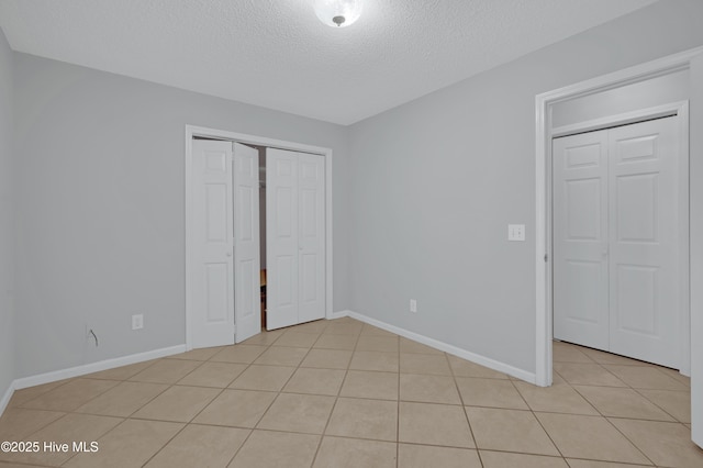 2910 Mulberry Ln Unit B, Greenville, NC 27858 - unfurnished bedroom featuring a textured ceiling, light tile patterned floors, and a closet