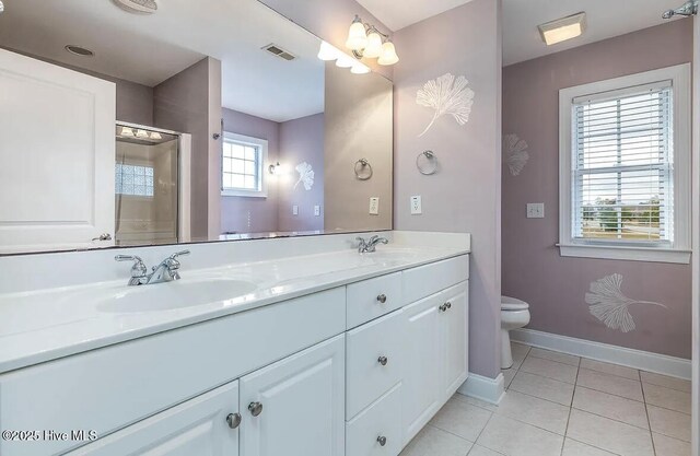 bathroom featuring a sink, tile patterned flooring, toilet, baseboards, and visible vents