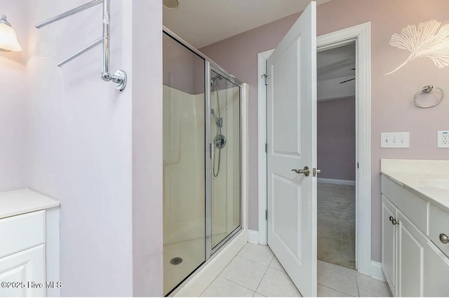 full bathroom featuring tile patterned flooring, baseboards, a stall shower, and vanity