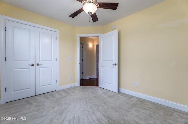 unfurnished bedroom featuring carpet floors, baseboards, a ceiling fan, and a closet