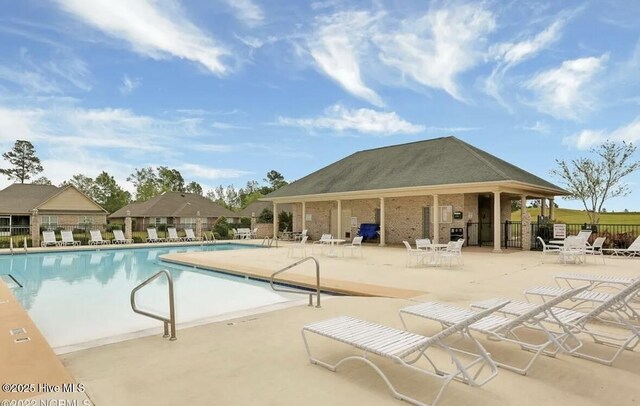 community pool featuring fence and a patio area