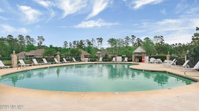 community pool featuring fence and a patio