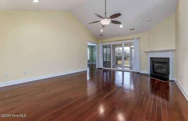 unfurnished living room featuring high vaulted ceiling, a glass covered fireplace, a ceiling fan, visible vents, and dark wood-style floors
