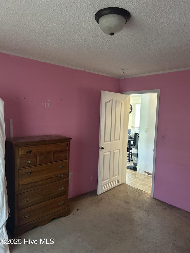 unfurnished bedroom with carpet floors, ornamental molding, and a textured ceiling