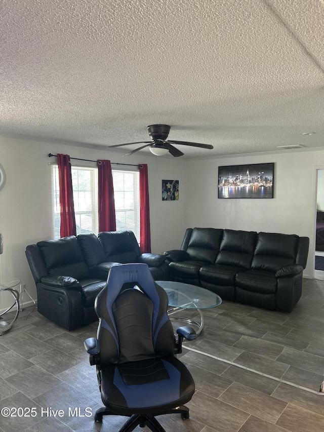 living room featuring a ceiling fan and a textured ceiling