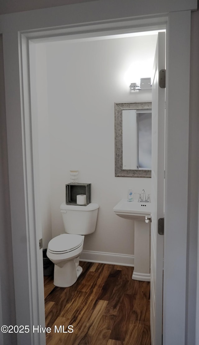 bathroom featuring baseboards, toilet, and wood finished floors