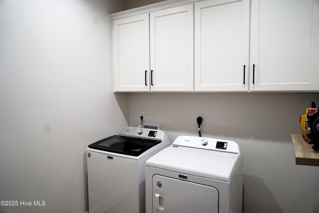 laundry room featuring independent washer and dryer and cabinet space