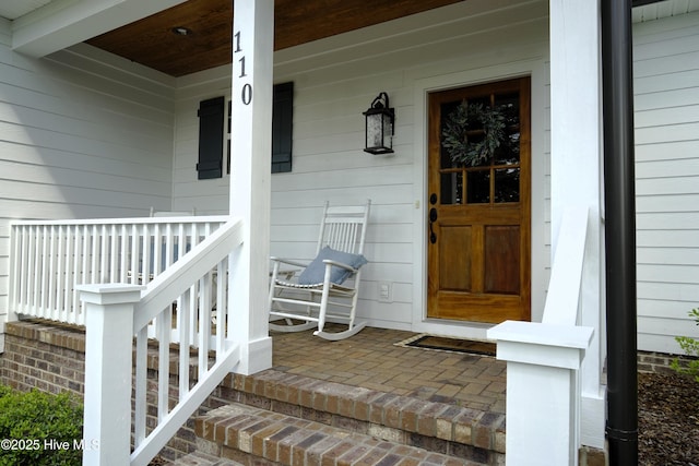 view of exterior entry with a porch