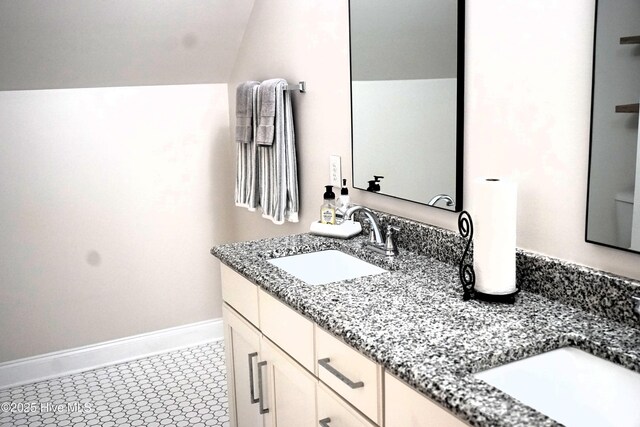 full bathroom featuring double vanity, a sink, and baseboards
