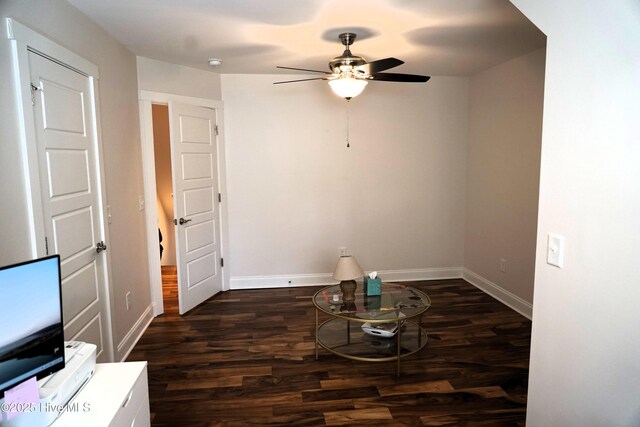 interior space with dark wood-style flooring, a ceiling fan, and baseboards