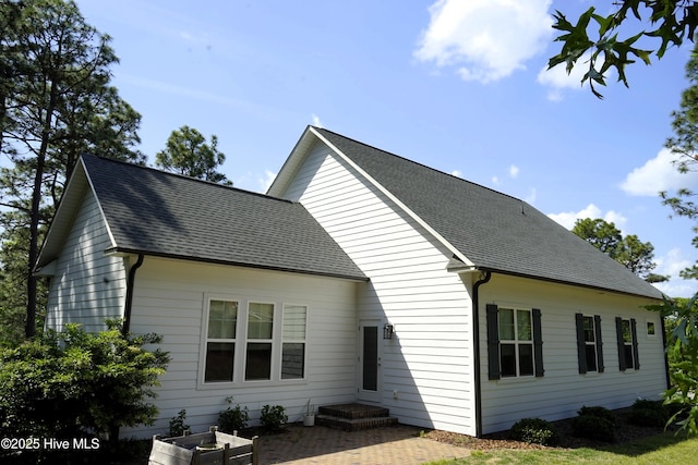 back of property with roof with shingles