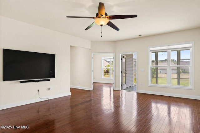 unfurnished living room with baseboards, ceiling fan, plenty of natural light, and wood finished floors
