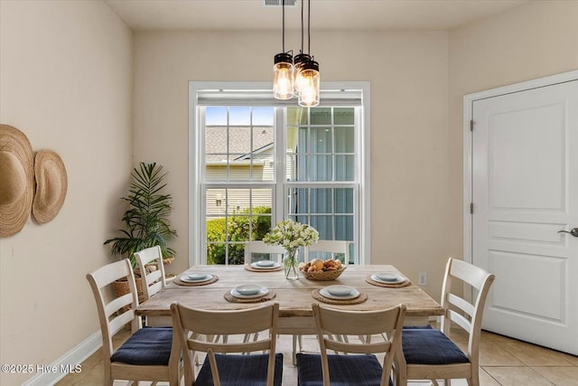 dining area with baseboards, plenty of natural light, light tile patterned flooring, and a notable chandelier