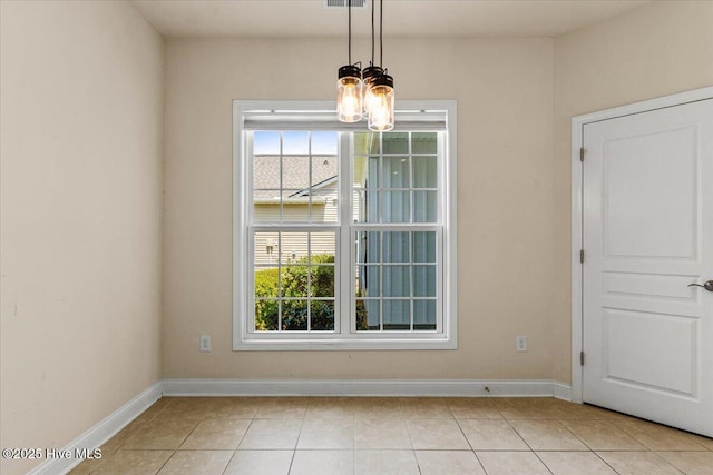 unfurnished dining area with light tile patterned floors, baseboards, an inviting chandelier, and a healthy amount of sunlight