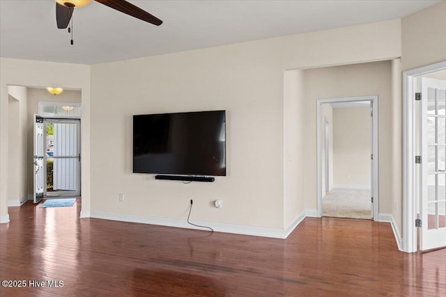 unfurnished living room with baseboards, ceiling fan, and wood finished floors