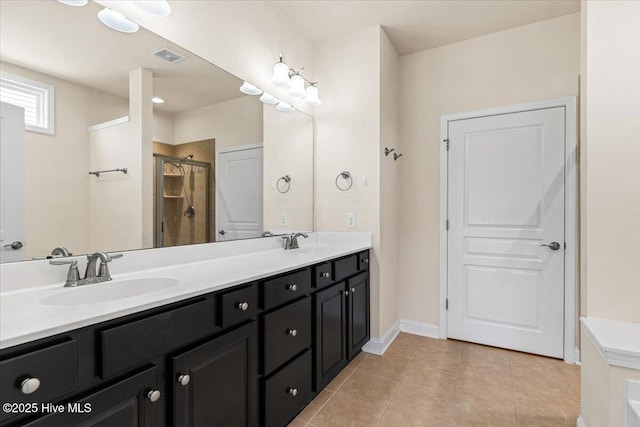 full bath with double vanity, a sink, a stall shower, and tile patterned flooring