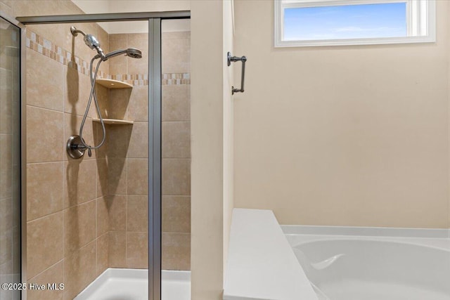 bathroom featuring a bath and a stall shower
