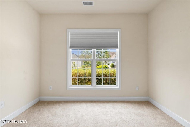 carpeted empty room featuring baseboards and visible vents