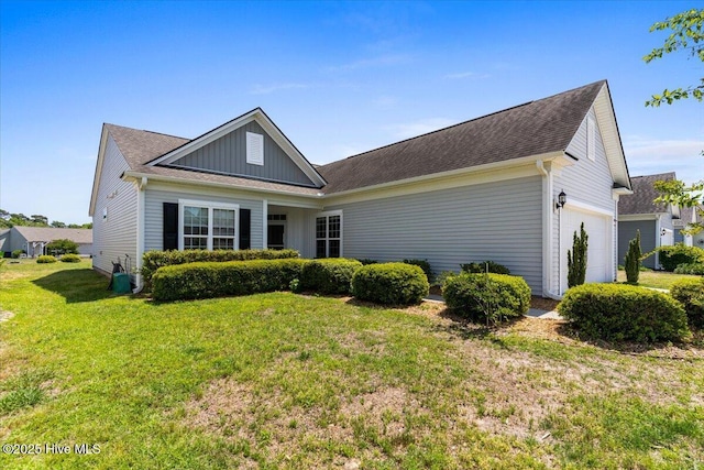 ranch-style house featuring a garage, board and batten siding, and a front yard