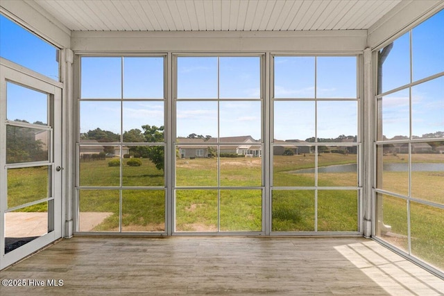 unfurnished sunroom featuring a water view