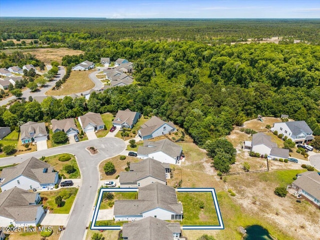 drone / aerial view featuring a residential view and a forest view
