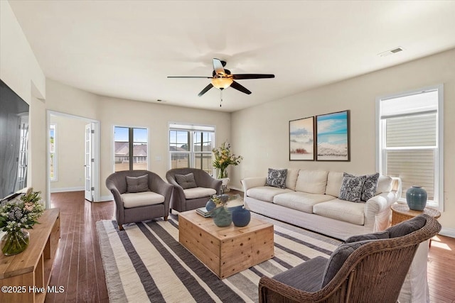living area with baseboards, a ceiling fan, dark wood-style flooring, and visible vents