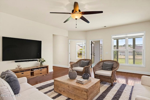 living area featuring baseboards, a ceiling fan, wood finished floors, and visible vents