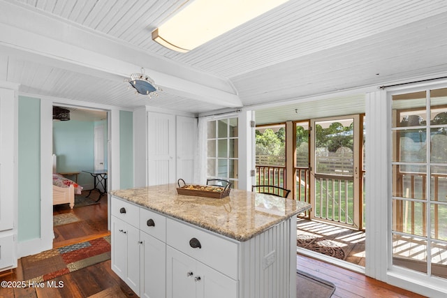 312 E W St, Southport, NC 28461 - kitchen featuring dark wood-style flooring, white cabinets, light stone countertops, a kitchen island, and wood ceiling