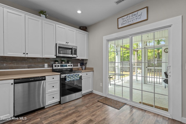 kitchen with stainless steel appliances, decorative backsplash, light countertops, white cabinets, and recessed lighting