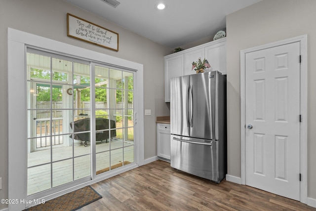 kitchen with freestanding refrigerator, white cabinetry, dark wood finished floors, baseboards, and recessed lighting