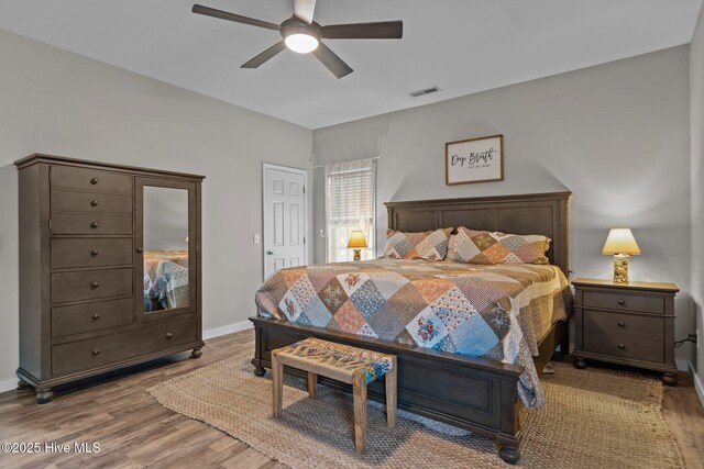 bedroom with wood finished floors, baseboards, and ceiling fan