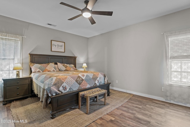 bedroom featuring wood finished floors, baseboards, and a ceiling fan