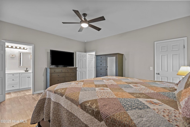 bedroom featuring light wood-style floors, a sink, connected bathroom, and ceiling fan