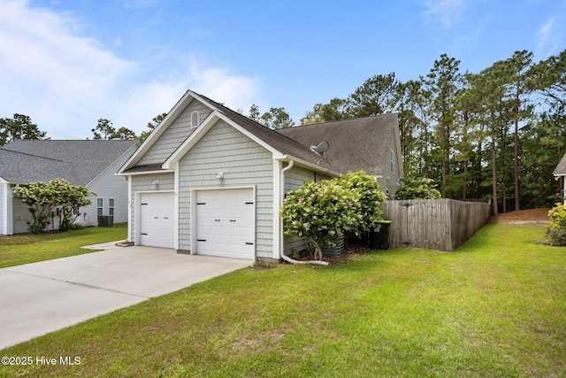 view of side of property with driveway, an attached garage, and central AC