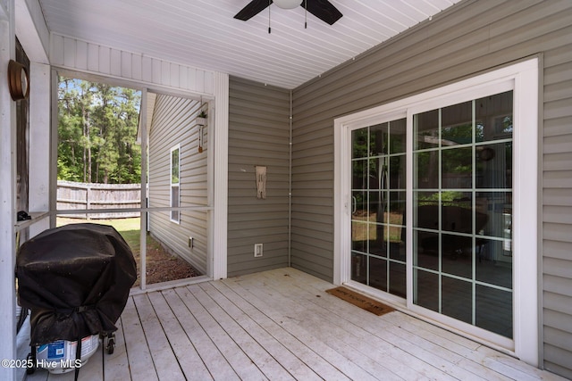 wooden deck featuring a ceiling fan, area for grilling, and fence